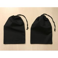 two black drawsacks are sitting on a white surface, one is open and the other is closed