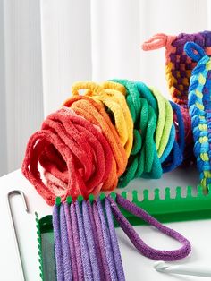 there are many different colors of yarn on the table next to scissors and combs