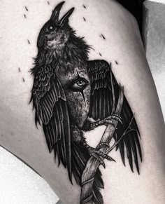 a black and white photo of a bird on the side of a woman's thigh