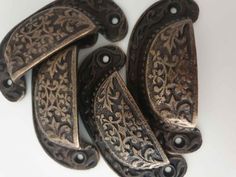 four antique style door handles on a white surface