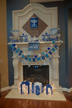 a mantel decorated with blue and white decorations for hanukkah in front of a fireplace