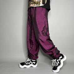 "Vintage Track Pants Purple Nylon Chameleon Joggers Baggy Fit Elastic Cuffs has Ankle Zippers Lined 90s Skate / Streetwear Great Condition: 9/10 Men's Size: X-Large My Hands in Pockets = It has Pockets No Hands in Pockets = Does Not Have Pockets Drawstring Will be Visible in Forward Pic, if not Visible it Does Not Have a Drawstring About me: I am 6' 0\" for reference I generally wear a Large (32\" inseam) I Model XS to 2XL sweatpants, I find that you can often size up or down with 95% of sweatpants and they fit the same" 90s Style Pants For Streetwear In Fall, Retro Winter Streetwear Bottoms, 90s Style Pants For Fall Streetwear, 90s Style Fall Streetwear Pants, Stretch Parachute Pants For Hip Hop Streetwear, Hip Hop Parachute Pants For Fall, Trendy Stretch Parachute Pants For Streetwear, 90s Baggy Parachute Pants For Spring, Trendy Nylon Pants For Streetwear