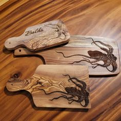 three wooden cutting boards with octopus designs on them