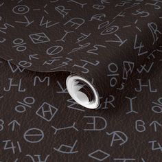 a close up view of the letters and numbers on a wallpapered surface, with an oval hole in the middle