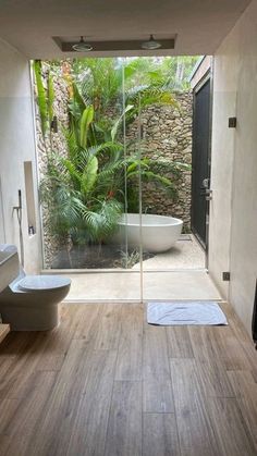 a bath room with a tub a toilet and a window