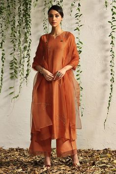 Spice orange kurta with placement leaf hand embroidery and scalloped sheer panelled sleeves. Paired with scalloped edged pant and embroidered dupatta.
Components: 3
Pattern: Embroidered
Type Of Work: Nakshi, Zari
Neckline: Notched
Sleeve Type: Scallop
Fabric: Kurta: Chanderi, Pant: Cotton Satin, Dupatta: Organza, Lining: Cotton
Color: Orange
Other Details: 
Sheer panelled pant
Length:
Kurta: 47 inches
Pant: 37 inches
Dupatta (LXW): 90 X 20 inches
Occasion: Puja - Aza Fashions Satin Dupatta, Red Kurta, Orange Spice, Scallop Edge, Organza Dupatta, Kurta With Pants, Saree Look, Desi Fashion, Kurta Designs