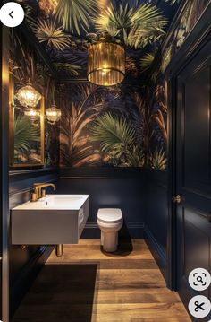 a bathroom with a toilet, sink and palm tree wallpaper on the walls in it