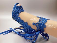 a woman's blue high heeled shoe with lace and beads on the side