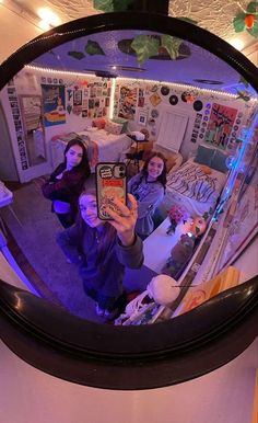 three people taking a selfie in a mirror