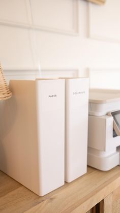 two white boxes sitting on top of a wooden shelf next to a printer and scanner