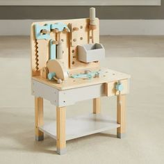 a wooden toy work bench with tools on it