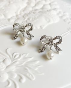 Silver Plated Brass Rhinestone Bow Earrings. Cubic zirconia and pearl shell pearls. Perfect French Style Summer earrings. All items come in a gift box ready to gift. To see more please visit  https://www.etsy.com/shop/BijouLimon Bijou Limon jewelry collections present a romantic French spin on the latest jewelry trends. Based on the US West Coast but French at heart, Bijou Limon interprets the current jewelry trends and delivers timeless pieces that make you swoon. From Necklaces, Earrings, Brac Exquisite Pearl Earrings For Gifts, Glamorous Pearl Drop Jewelry As Gift, Exquisite Diamond White Pearl Earrings For Wedding, Diamond Pearl Charm Earrings For Wedding, Diamond Pearl Earrings For Wedding, Wedding Pearl Earrings With Diamond Charm, Elegant Diamond Pearl Earrings For Wedding, Pearl White Diamond Earrings For Wedding, Silver Party Pearl Earrings With Pearl Chain