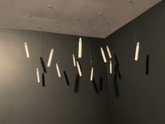 several toothbrushes hanging from the ceiling in a room with dark walls and white paint