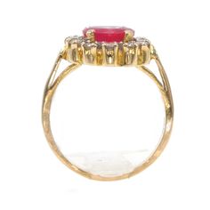 One thing that all rubies have in common is that they're red. Some are pink-red, some are purple-red, and some are RED red. This ruby is that fantastic "red" that one thinks of when one hears the word "ruby." At the center of this ring is a 7.5mm flux (chamber grown) rich red ruby. It's prong set and surrounded by a halo of 0.49ct of eye white, eye clean diamonds. The entire ring is made of 18K yellow gold and the buttery-yellow color of the gold beautifully sets off the color of the ruby. Metal Red Ruby Ring With Halo, Red Ruby Ring With Halo In Fine Jewelry Style, Formal Ruby Ring With Halo, Formal Red Ruby Ring With Halo, Fine Jewelry Red Ruby Ring With Halo, Red Ruby Cluster Ring With Halo Setting, Pink Ruby Rings With 17 Jewels, Yellow Gold Ruby Ring With Halo, Red Ruby Ring With Halo Detail