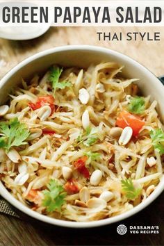 green papaya salad in a white bowl on a wooden table