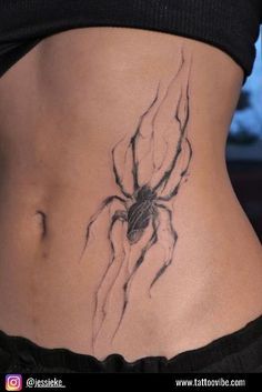 a woman's stomach with a spider tattoo on it