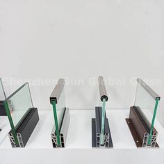 four different types of glass on display in a white case with metal bars and green handles