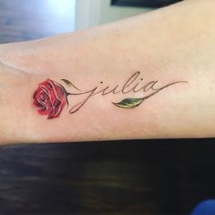 a tattoo with the word julia written on it and a single rose in its center