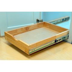 a wooden tray sitting on top of a table next to a door and window sill