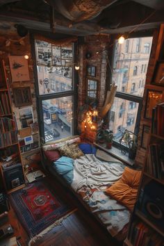 a bed sitting next to a window in a room with lots of books on the shelves