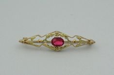 "Vintage 10K two color gold broach/pin set with a 1 carat oval created ruby. Beautifully balanced with flowers and petals, the two colors of gold bring a warmth to the deep red of the ruby. There is a very small chip near the girdle of the ruby but hard to see without magnification. This is a wonderful example of art in jewelry. FREE SHIPPING! Details: 10K Two Color Gold (shown in picture) Created Ruby: (1) 5 mm x 7 mm oval Stone Color: Ruby Red Approximate Stone Weight: 1 ct. Approximate Dimens Oval Yellow Gold Brooches With Gemstone, Ornate Oval Brooches For Anniversary, Formal Ruby Brooch Jewelry, Ornate Oval Anniversary Brooches, Yellow Gold Oval Brooch For Wedding, Oval Gemstone Brooches For Anniversary, Oval Brooch In Fine Jewelry Style For Formal Occasions, Oval Gemstone Brooches For Weddings, Jewellers Bench