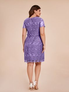 a woman wearing a purple dress with floral lace on the waist and sleeves, back view