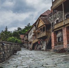 an old cobblestone street lined with stone buildings and wooden balconies on either side