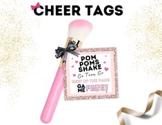 a pink brush with a black bow on it next to a card that says pom poms shake g - town go