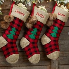 two christmas stockings hanging from a tree with personalized names on them and pom - poms