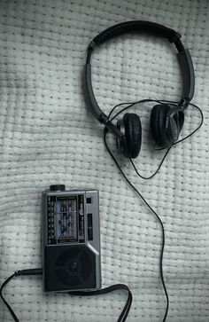 an old radio and headphones laying on a bed