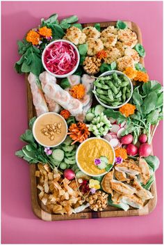 a platter filled with different types of food on top of a pink tablecloth