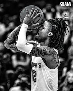 a man with dreadlocks holding a basketball