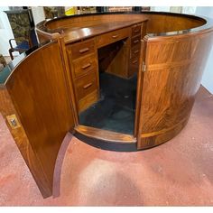 a wooden desk with an open door on the top and bottom section, in a room