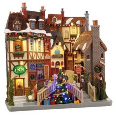 a christmas village with lights and decorations on the outside, including a lit up tree