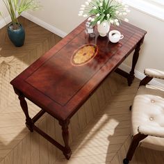 a wooden table sitting on top of a hard wood floor next to a white chair