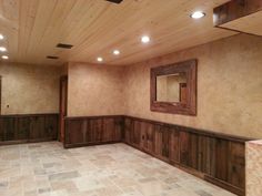 an empty room with wood paneling and tile flooring on the walls is shown