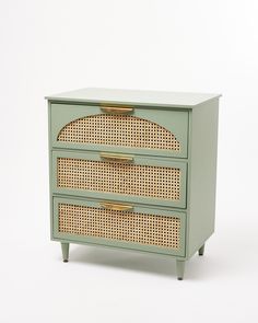 a green dresser with wicker drawers on it's sides and gold handles, against a white background