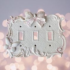 a white double light switch plate with a bow on the front and two toggles