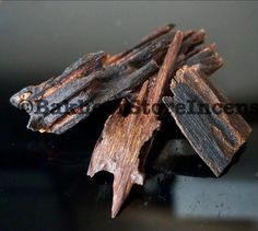 several pieces of wood sitting on top of a black table next to a glass container