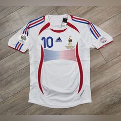 a soccer jersey with the number 10 on it sitting on a wooden floor in front of a wall