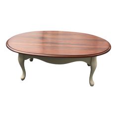 an oval wooden table with white legs and a wood top, against a white background