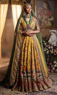 Pakistani Bridal Dress in Yellow Lehenga Choli Style is a classic masterpiece that will give the gorgeous bride a head-turning glamorous look on the most important day of your life. Lavish designs and embellishments give a perfect finishing to this stunning Bridal Lehenga Choli. Lehenga Choli: The choli is in an alluring yellow color is gracefully embellished with intricate designs, zardosi, sequins, tilla, and Resham. Shimmering ornaments, hanging motifs, and lavish contrast of colors make this choli a perfect choice to pair with the Bridal Lehenga. Bridal Lehenga: This Bridal Lehenga is emblazoned with the intricate designs, dabka, tilla, kora, Resham work, sequins, and crystals. The Yellow Lehenga has a huge flare and is adorned with Shimmering details and floral designs, making this Pa Unstitched Wedding Lehenga With Tilla Embroidery, Wedding Lehenga Unstitched With Tilla, Unstitched Tilla Lehenga For Wedding, Raw Silk Gown With Pallu For Wedding, Wedding Lehenga In Raw Silk With Dabka Detailing, Raw Silk Wedding Gown With Pallu, Yellow Wedding Dress With Intricate Embroidery, Bollywood Style Wedding Gown With Tilla, Bollywood Style Wedding Gown With Tilla Detailing