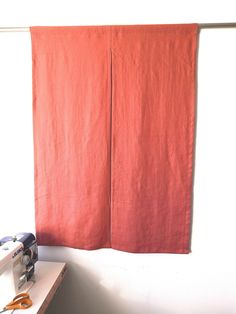 an orange piece of cloth hanging on a wall next to a sewing machine