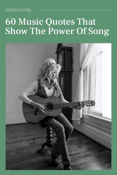 a woman sitting on top of a chair holding a guitar in front of a window