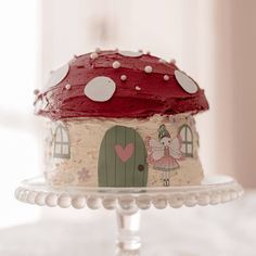 there is a cake that looks like a fairy house on top of the cake stand