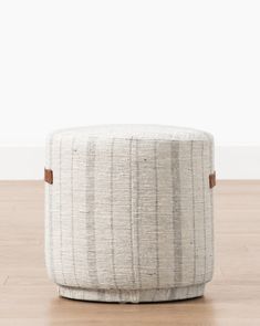 a small round ottoman sitting on top of a wooden floor