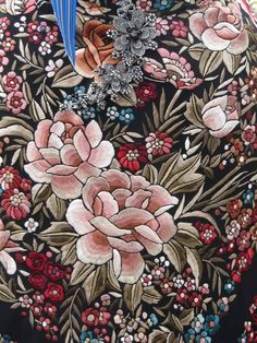 a close up of a woman's dress with flowers and birds on it