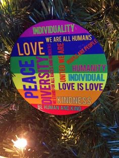 a colorful ornament hanging from a christmas tree with the words peace on it