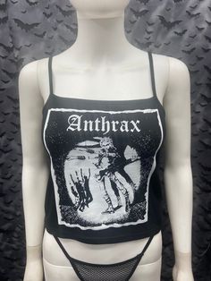 This is a black Anthrax crop tank top with spaghetti straps. This has a Anthrax image screen printed on the front. 57% cotton/ 38% polyester/ 5% Spandex These are handmade screenprinted and slightly vary from the photo. Please feel free to email me any questions. Thanks for looking. Due to an influx of incorrect addresses if a package is returned, you must pay the shipping cost to resend the item to you. The seller is not responsible for any lost or stolen packages. Fitted Black Crop Top Band Merch, Fitted Alternative Style Tank Top With Graphic Print, Black Edgy Tank Crop Top, Edgy Black Tank Crop Top, Fitted Black Emo Tank Top, Fitted Black Emo Style Tank Top, Fitted Graphic Print Tank Top For Alternative Fashion, Black Tank Crop Top For Streetwear, Fitted Punk Tank Top With Graphic Print