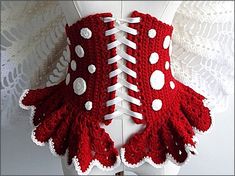 a red and white crocheted corset with polka dots on the bottom